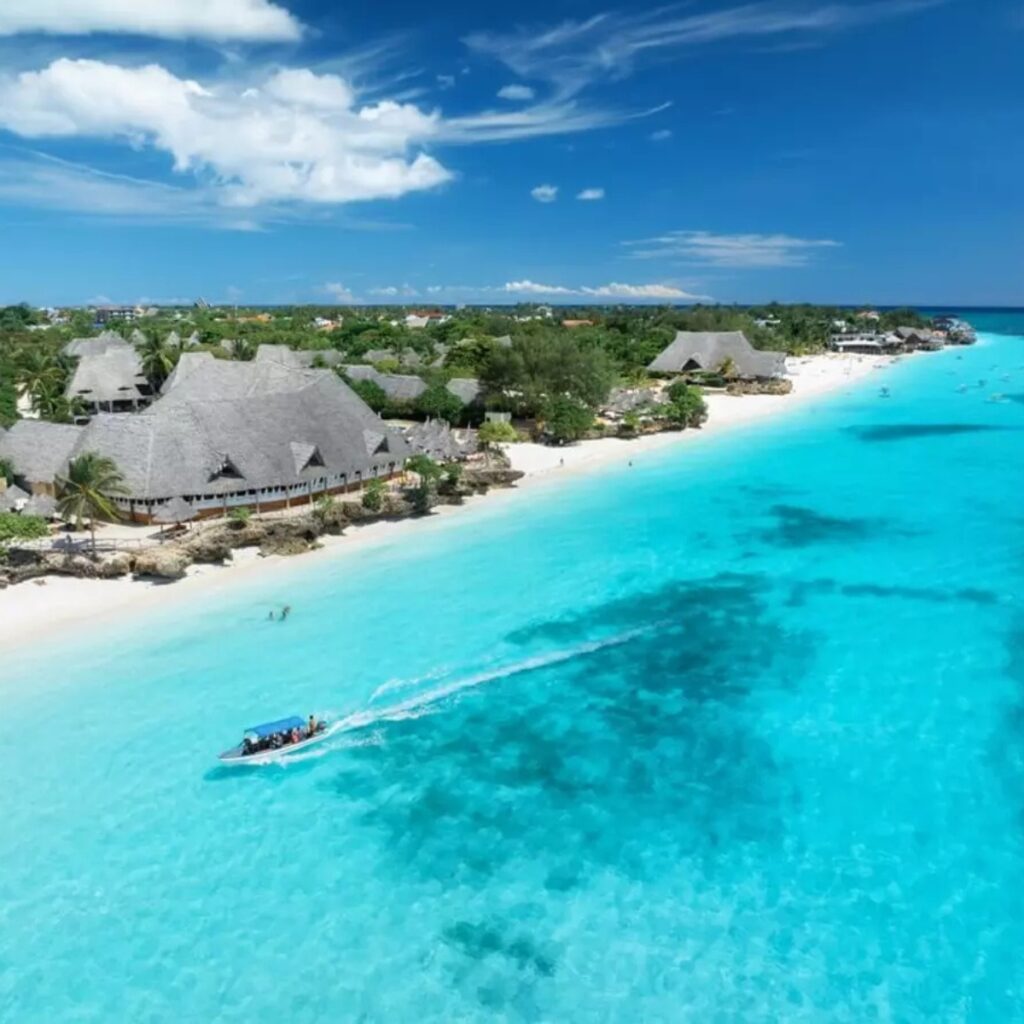 Cómo llegar a Zanzíbar desde España. Palmeras, mar con agua de color turquesa, arena blanca, vacaciones en Tanzania