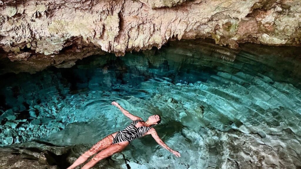 joven nadando en el lago azul de Kuza Cave, en Jambiani. Agua transparente. Cueva